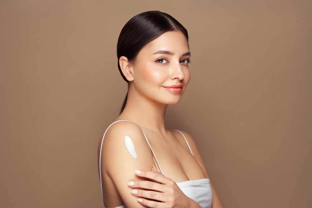 Cropped,Shot,Of,A,Young,Tanned,Woman,Moisturizing,Her,Shoulder spot free