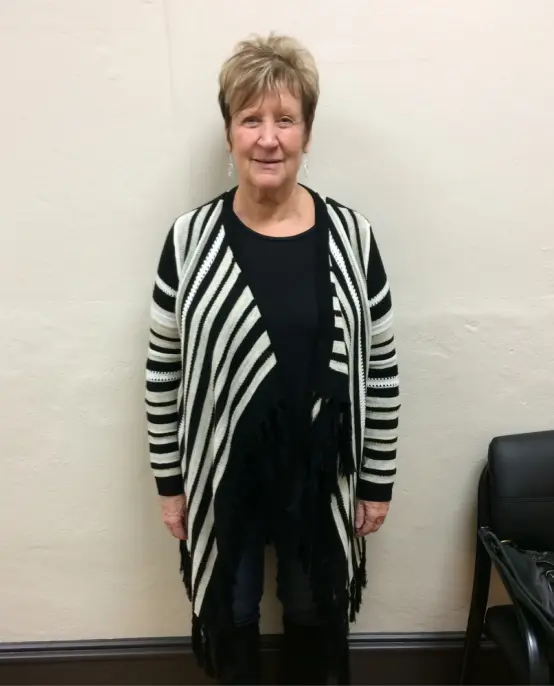 Smiling woman in a striped cardigan.